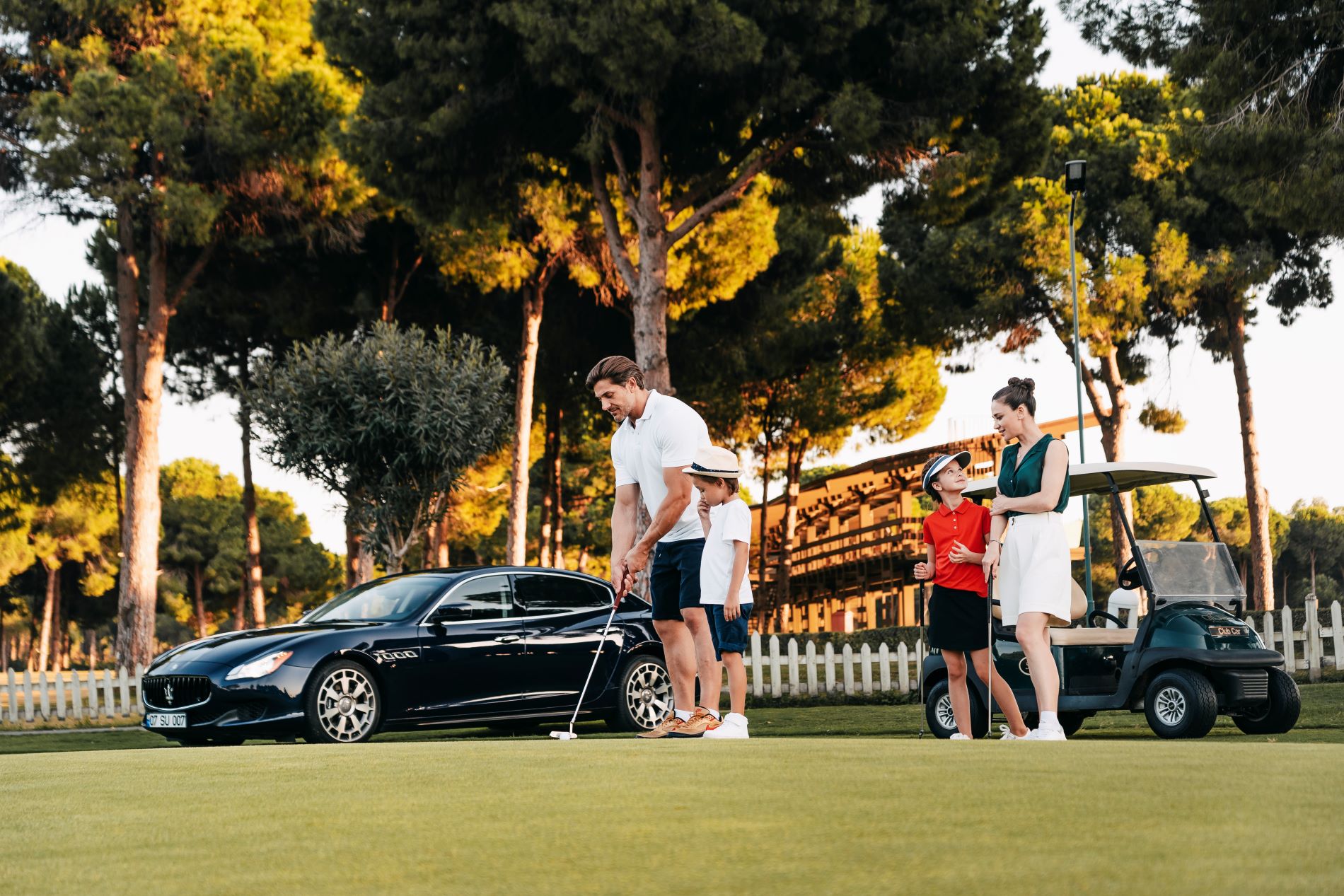 Ein ANEX Priority Auto hält vor einem Hotel, während eine Familie Golf spielt.