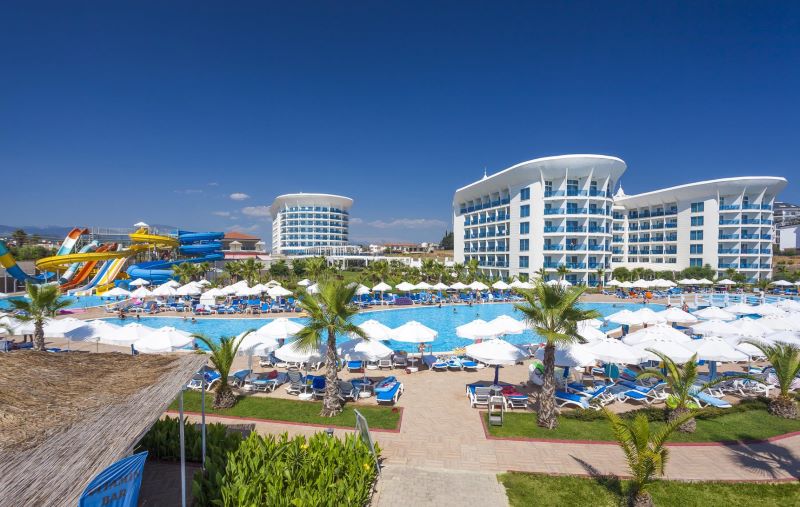 Der 150 Meter hohe Dubai Frame, der aussieht wie ein riesiger goldener Bilderrahmen, umgeben von Palmen an einem schönen Sommertag.