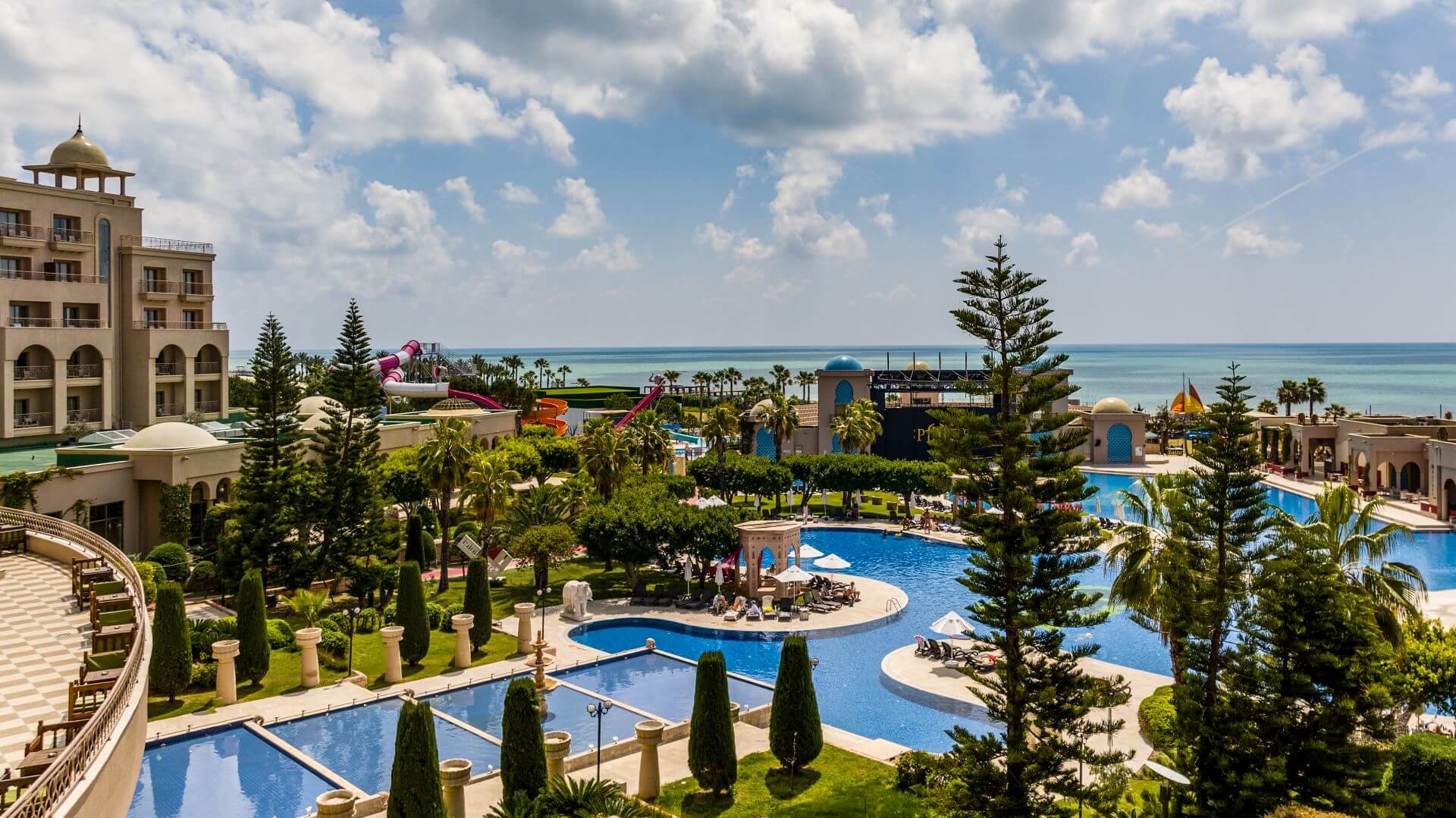 Hotelanlage des Spice Hotels mit Blick hinaus auf das Meer an einem sonnigen Tag.