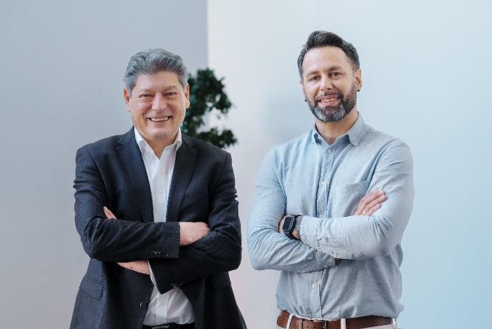 Portrait von zwei ANEX Mitarbeitern, die vor der Kamera posieren.
