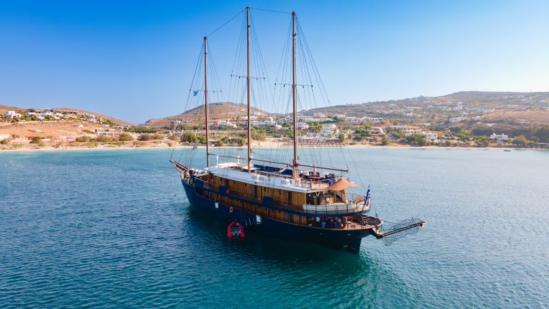 Motor-Yacht gleitet durch das tiefblaue Wasser zwischen griechischen Inseln