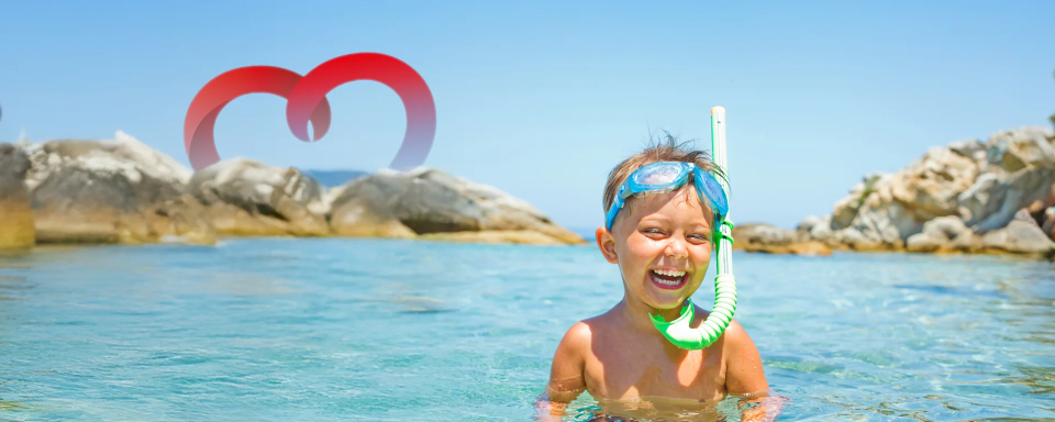 Kind mit Tauchmaske lacht im Meer