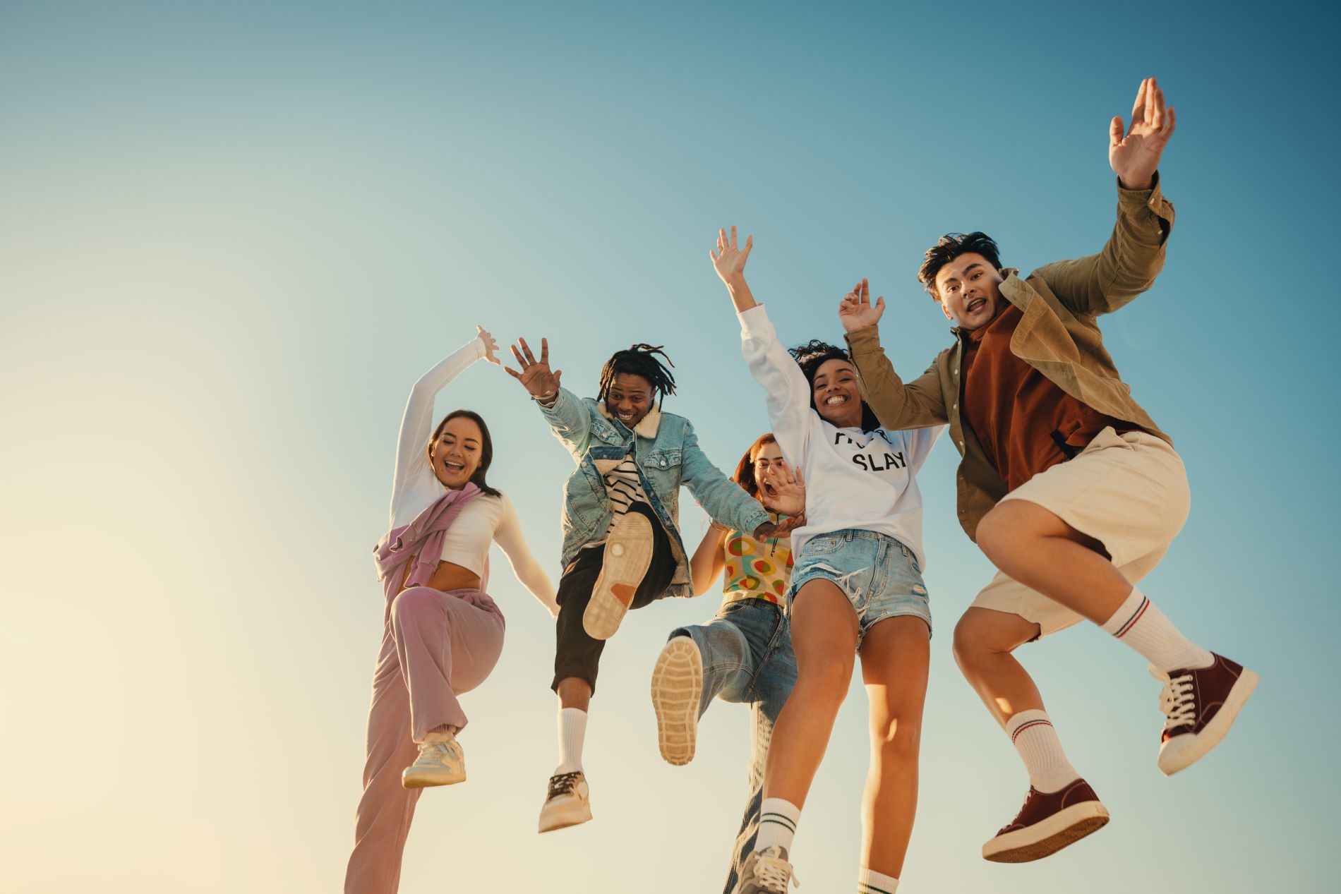Eine Gruppe von Freunden springt vor Freude auf ihren Urlaub.